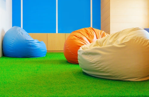 Three beanbags on indoor artificial lawn floor.